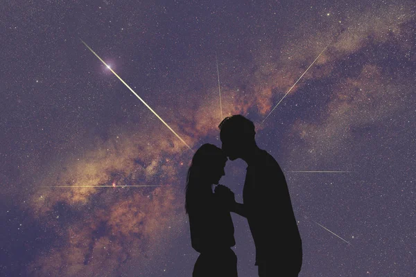 Silhouettes of a young couple under the starry sky