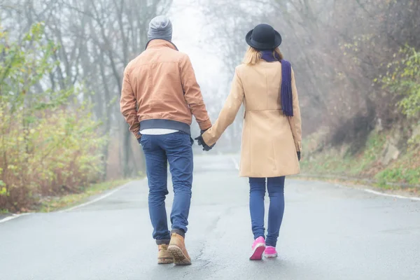 甘いカップルは手を繋いでいると秋の公園でウォーキング — ストック写真
