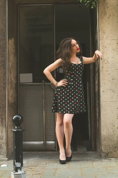 stock image Cute girl posing in front of a building entrance.