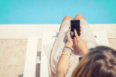 Cep telefonu yüzme havuzu kullanan kız.