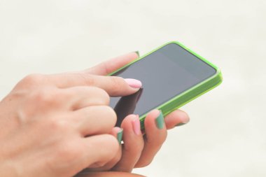 Açık havada cep telefonu kullanırken bir kızın detay.