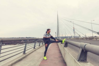 Kentsel jogger bir köprüde germe.