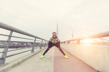 Kentsel jogger bir köprüde germe.
