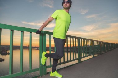 Kentsel jogger nehrin üzerinde bir köprü'nde günbatımı germe / gündoğumu kez.