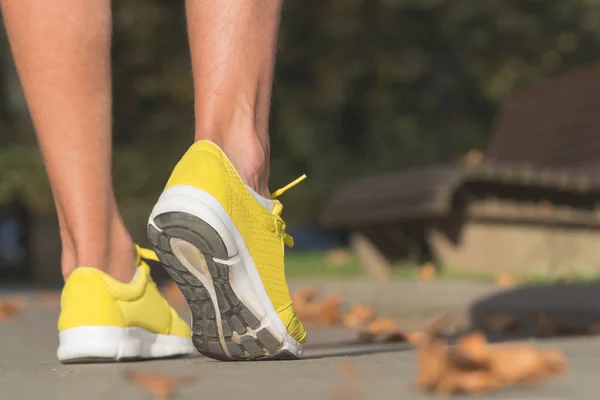 Detail of a running man\'s shoes / sneakers in the park.