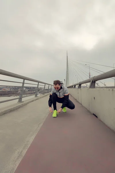 Hombre Atando Zapatillas Gran Puente —  Fotos de Stock