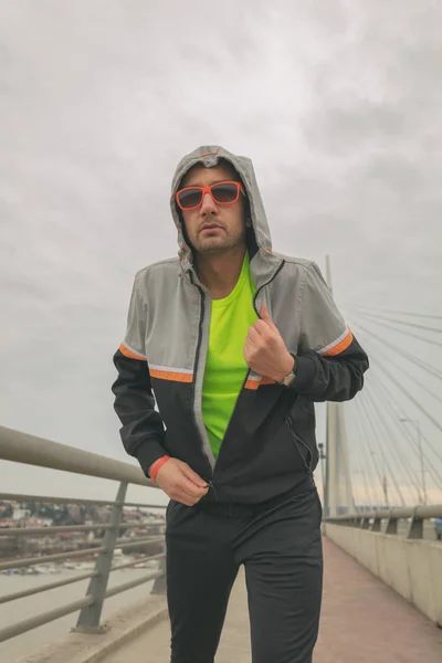 Man preparing for exercise on a big bridge.