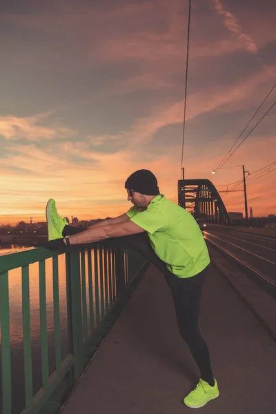 Städtischen Jogger Erstreckt Sich Auf Einer Brücke Über Dem Fluss — Stockfoto
