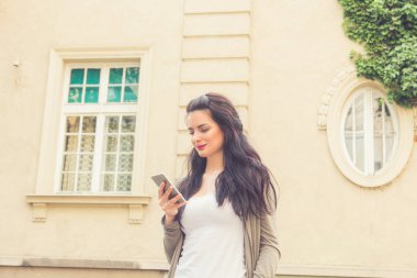 Kentsel ortamda cep telefonu kullanarak sevimli genç kız