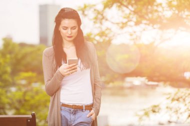 Kentsel ortamda cep telefonu kullanarak sevimli genç kız