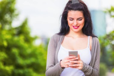 Kentsel ortamda cep telefonu kullanarak sevimli genç kız