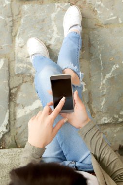 Açık havada merdivenlerde otururken kız manifatura.