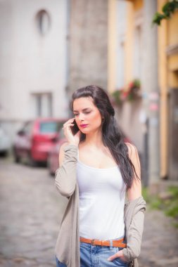 Sevimli kız sokakta cep telefonu kullanarak.