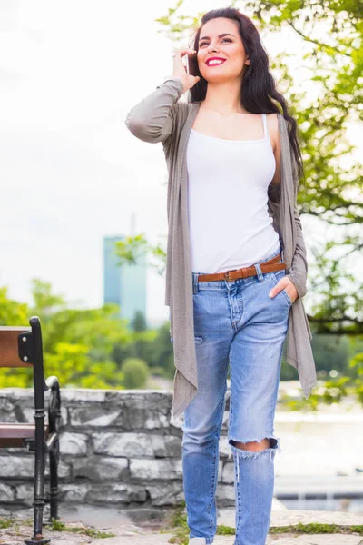 Kentsel ortamda cep telefonu kullanarak sevimli genç kız