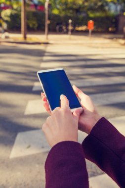 Kentsel ortamda cep telefonu tutan kız