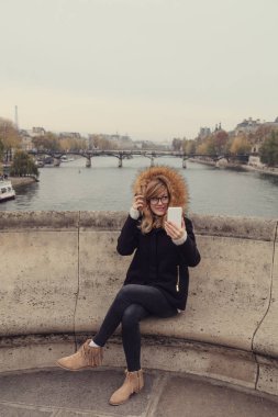 Paris, Fransa'da cep telefonu kullanan sevimli genç kadın.