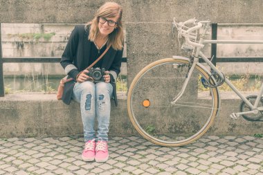 Kız sokakta poz kamera bisiklet ve retro.