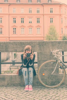 Kız sokakta poz kamera bisiklet ve retro.