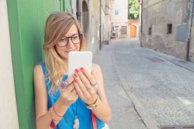 Kentsel ortamda cep telefonu tutan şirin kadın.