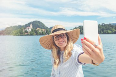 Göl kenarında cep telefonu kullanan şirin kız.