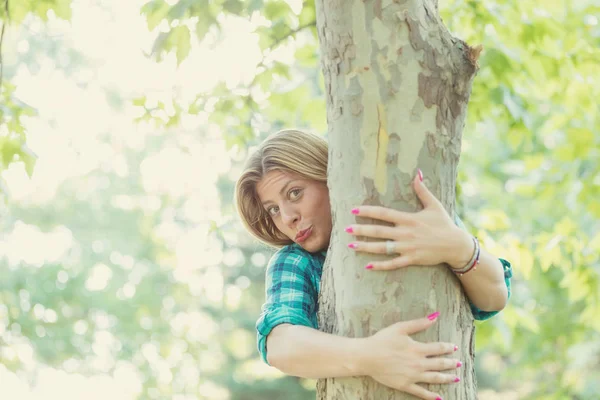 可爱的笑脸金发女郎触摸树的自然 — 图库照片