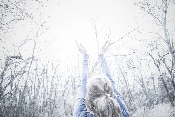 女孩用手在空中期待季节的第一雪 — 图库照片