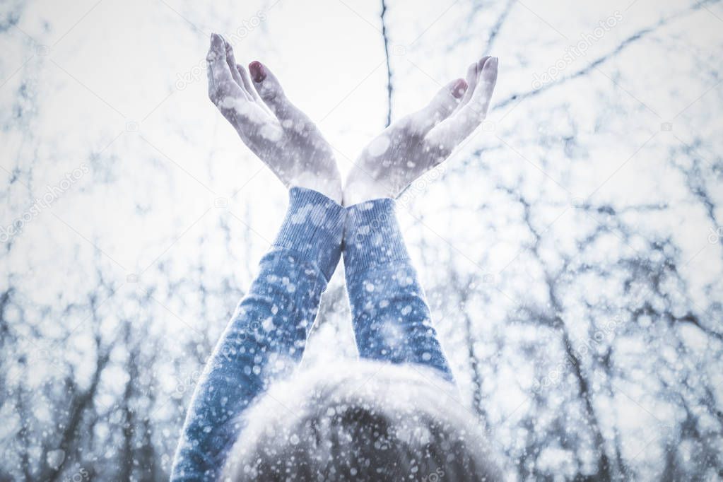Girl with hands in the air expecting first snow of the season.