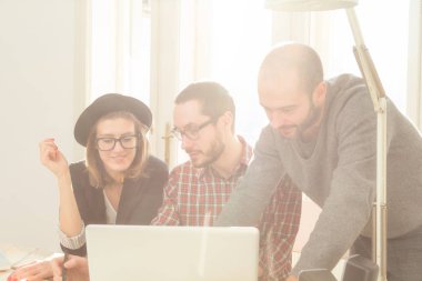 Tarafından doğal güneş ışığı yaktı bir odada genç grup insan iş planları, lap-tops ile tartışırken planları.