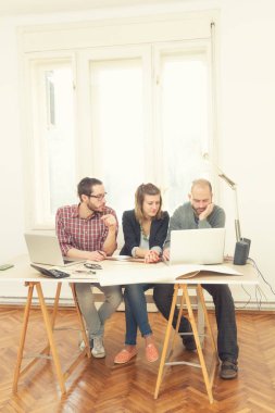 Gençlerin grup iş planları, lap-tops ile tartışırken sıradan bir oda tarafından doğal güneş ışığı yaktı planları.