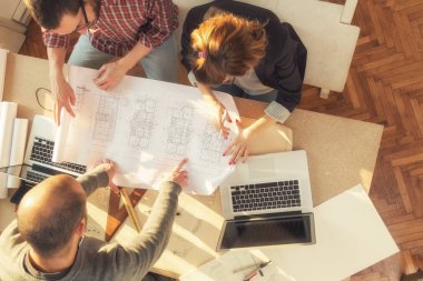 Gençlerin grup iş planları, lap-tops ile tartışırken sıradan bir oda tarafından doğal güneş ışığı yaktı planları.