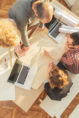 Gençlerin grup iş planları, lap-tops ile tartışırken sıradan bir oda tarafından doğal güneş ışığı yaktı planları.