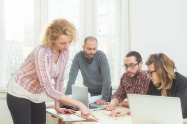 Gençlerin grup iş planları, lap-tops ile tartışırken sıradan bir oda tarafından doğal güneş ışığı yaktı planları.