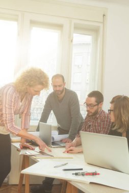 Gençlerin grup iş planları, lap-tops ile tartışırken sıradan bir oda tarafından doğal güneş ışığı yaktı planları.