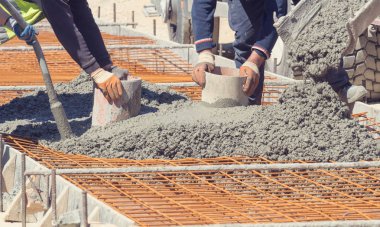 İnşaat işçileri beton kaldırım açık havada tesviye.