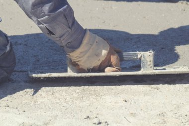 İnşaat işçisi beton kaldırımları düzlüyor..