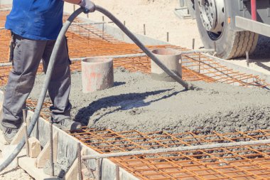 İnşaat işçisi beton kaldırımları düzlüyor..