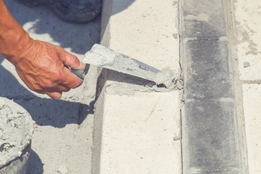 İnşaat işçisi beton kaldırımları düzlüyor..