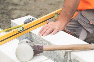 İnşaat işçisi beton kaldırımları düzlüyor..