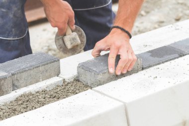 İnşaat işçisi zor tesviye beton kaldırım açık havada.