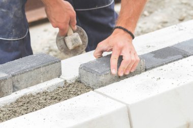 İnşaat işçisi zor tesviye beton kaldırım açık havada.