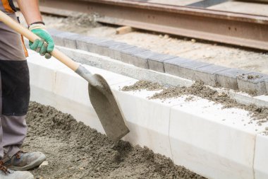 İnşaat işçisi zor tesviye beton kaldırım açık havada.