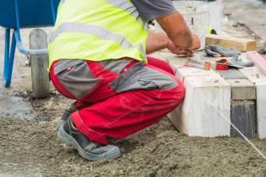 İnşaat işçisi wotking sert ve tesviye beton kaldırım açık havada.