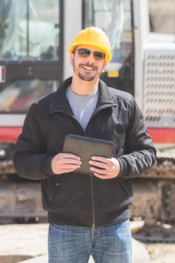 Gerçek ve sıradan inşaat işçisi tablet işini üzerinde kullanma.