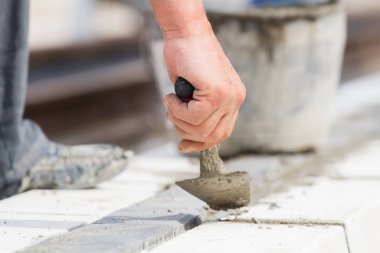 İnşaat işçisi çalışma sert ve tesviye beton kaldırım açık havada.