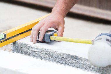 İnşaat işçisi beton kaldırımları düzlüyor..