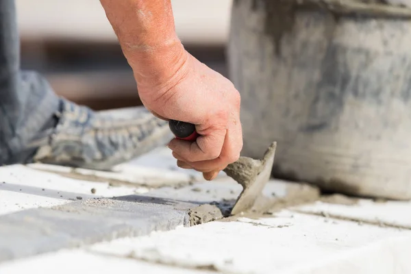İnşaat işçisi çalışma sert ve tesviye beton kaldırım açık havada.