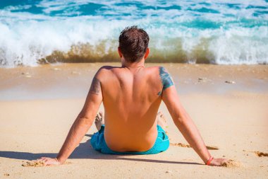 Yalan ve tropikal bir kumsalda zevk adam.