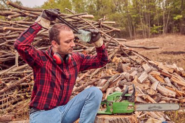 Testere ile kesme woods yığını ile oduncu.