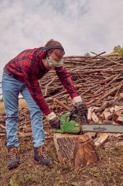 Testere ile kesme woods yığını ile oduncu.