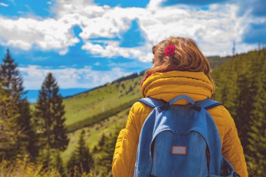 Kadın dağlık manzara seyir sırt çantası ile.